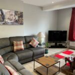 A living room with a grey corner sofa, coffee table and television
