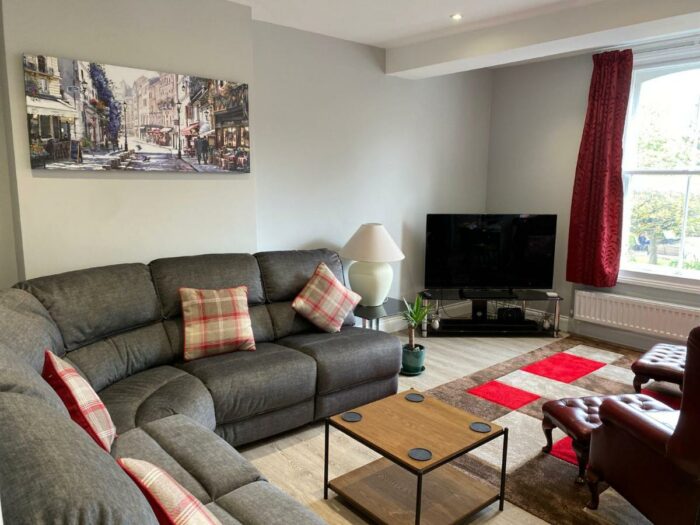 A living room with a grey corner sofa, coffee table and television